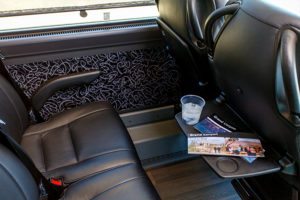 Inside luxury coach bus with tray table.