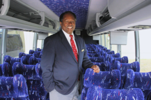 driver standing in the middle of the bus.