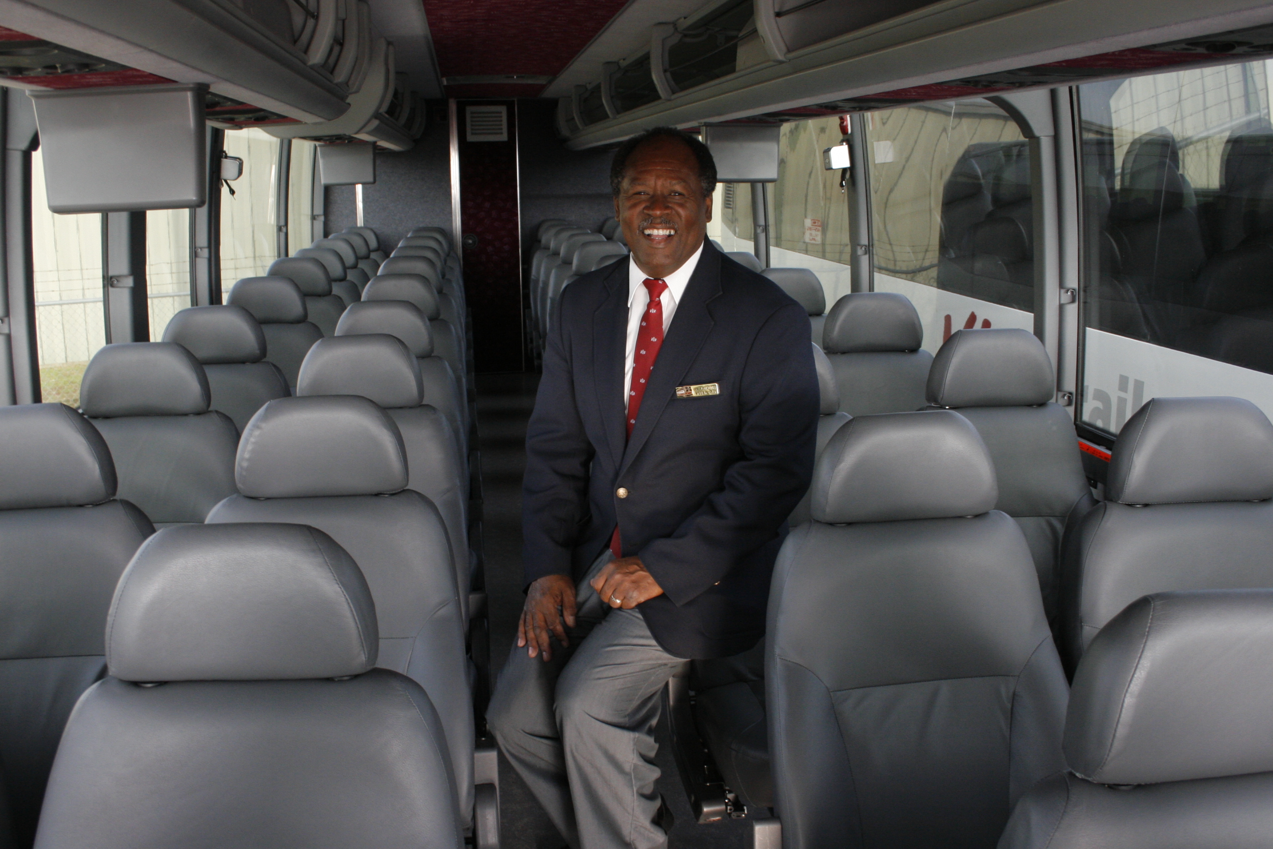 _MG_7303 Driver sitting on a bus seat smiling.